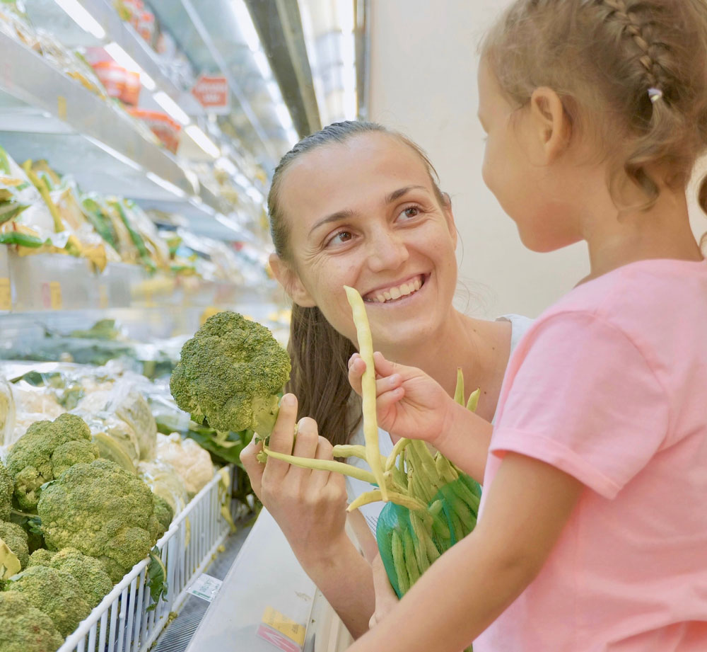 Young girl are smiling at each other in a grocery store