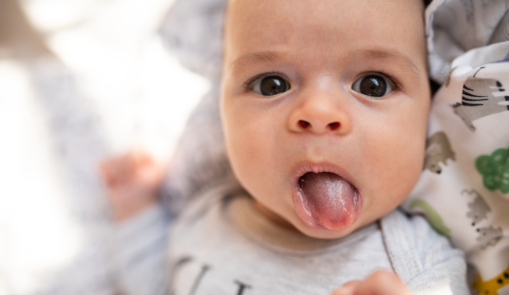 baby playfully sticking its tongue